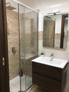 La salle de bains est pourvue d'une douche, d'un lavabo et d'un miroir. dans l'établissement TaoZen Apartments, à Taormine