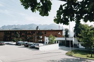 a building with cars parked in a parking lot at Klosterhof – Alpine Hideaway & Spa in Bad Reichenhall