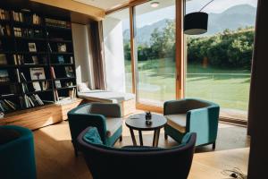 a living room with chairs and a table and a window at Klosterhof – Alpine Hideaway & Spa in Bad Reichenhall