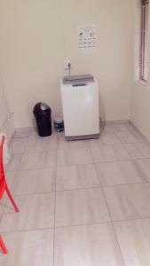 a small refrigerator in a room with a tile floor at Zanevovo in Scottburgh