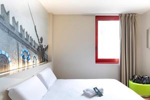 a room with a bed, a lamp, and a window at B&B Hotel Verona Sud in Verona