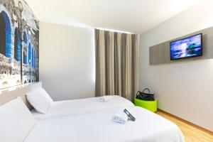 a hotel room with a television and a bed at B&B Hotel Verona Sud in Verona