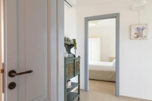 un pasillo con una puerta que conduce a un dormitorio en HelloAPULIA - Panoramic Trullo Blue Ocean View, en Monopoli