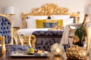 1 dormitorio con 1 cama y 1 mesa con copas de champán en Hôtel Saint-Martin - La Maison Younan en Saint-Maixent-lʼÉcole