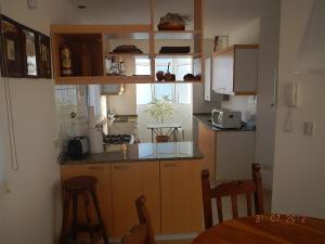 - une cuisine avec des placards en bois, une table et des chaises dans l'établissement Duplex Barrancas, à Puerto Madryn