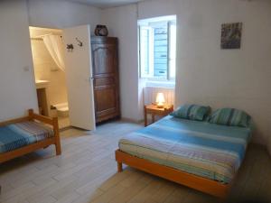 グロスピエールにあるchambre d'hôtes Lou Couradouの小さなベッドルーム(ベッド1台、冷蔵庫付)