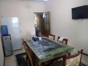 uma cozinha com uma mesa e um frigorífico em Samia House Room on Furqat 8 em Tashkent