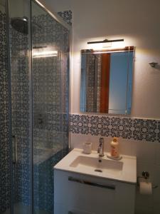 a bathroom with a sink and a shower with a mirror at Arbanella in Corniglia
