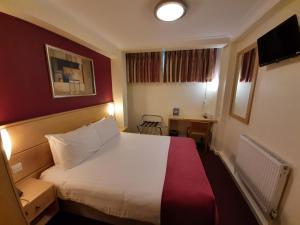 a hotel room with a large bed and a window at Americana Hotel in London