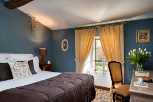 a bedroom with a bed and a window at Hôtel Saint-Martin - La Maison Younan in Saint-Maixent-lʼÉcole