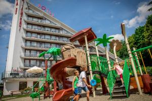 a group of children playing on a playground in front of a hotel at Spa & Wellness Hotel Diament Ustroń in Ustroń