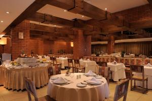 a dining room with tables and chairs with white tablecloths at Hotel El Araucano in Concepción