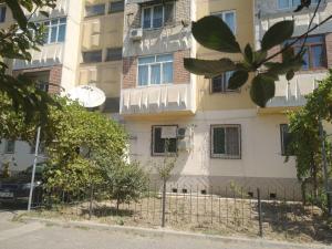 a building with a fence in front of it at Samia House Room on Furkat 8 in Tashkent +5 photos