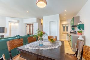 uma cozinha e sala de estar com uma mesa e um sofá verde em Kuća Redini em Sutivan