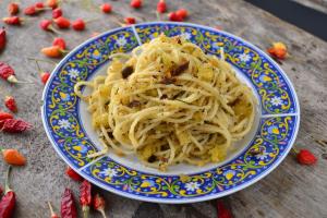 a blue and white plate of pasta on a table at La casa del corso in Aragona