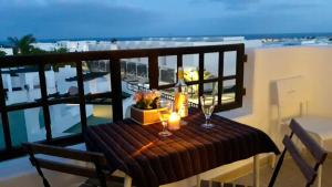 a table on a balcony with a view of the ocean at Aqua Apt Sunrise & Sea Views in Costa Teguise