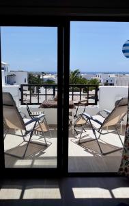 a view of a balcony with chairs and a table at Aqua Apt Sunrise & Sea Views in Costa Teguise