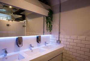 a bathroom with three sinks and a mirror at CoDE Pod – The CoURT - Edinburgh in Edinburgh