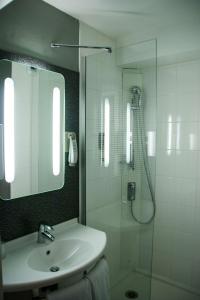 La salle de bains est pourvue d'un lavabo et d'une douche avec un miroir. dans l'établissement ibis Rambouillet, à Rambouillet