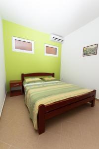 a bedroom with a bed with a green wall at Apartments Sergej in Sutomore