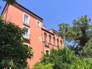 a red brick building with trees in front of it at Palazzo Gentilizio de Maffutiis in Auletta