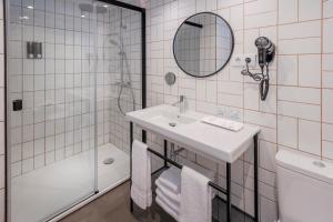 
a bathroom with a toilet, sink and mirror at GHT Miratge - Only Adults (+16) in Lloret de Mar
