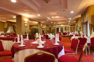 uma sala de banquetes com mesas e cadeiras num restaurante em Hotel Albatros em Serwy