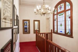 a hallway with a chandelier and stained glass windows at Bella Ev Guest House in Muizenberg