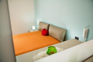 Un dormitorio con una cama con una almohada roja encima. en Sicilia Case Vacanze, en Balestrate