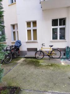 柏林的住宿－Wohnung 15，两辆停在白色建筑外的自行车