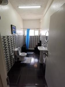 a bathroom with a toilet and a sink at TD Guest House 1 in Chimoio