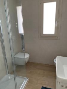 W łazience znajduje się toaleta i przeszklony prysznic. w obiekcie Appartamento Acquamarina w mieście San Benedetto del Tronto