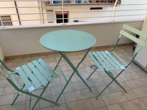 dwa krzesła i stół oraz stół i krzesła w obiekcie Appartamento Acquamarina w mieście San Benedetto del Tronto