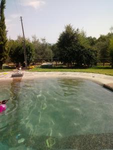 a woman sitting in a pool of water near a fountain at Elisabeth House in Lucignano