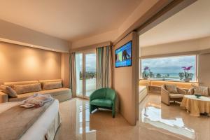 una camera d'albergo con un letto e una grande finestra di Acacia Palace a Marina di Ragusa