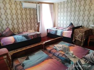 a room with three beds and a table at Downtown guest house in Kutaisi