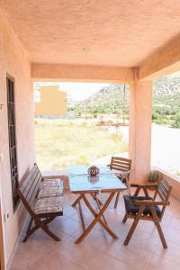 eine Terrasse mit einem Tisch und Stühlen auf einer Veranda in der Unterkunft Sounio Mare in Kap Sounion