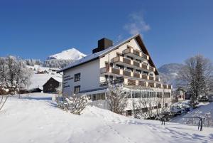 a large white building in the snow at Hotel Toggenburg in Wildhaus