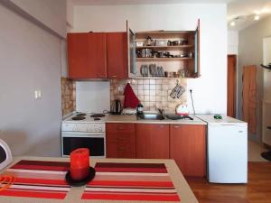 a kitchen with wooden cabinets and a white stove top oven at Philippos House in Florina +11 photos