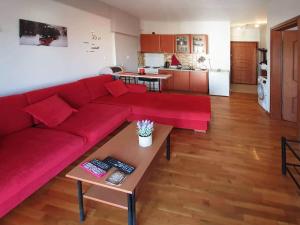 a living room with a red couch and a table at Philippos House in Florina