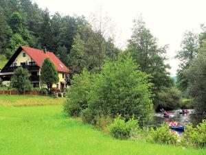 ein Haus auf einem Fluss mit Menschen in Booten in der Unterkunft Haus Wiesenttal in Waischenfeld