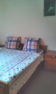 a bed with two pillows and a table in a room at Guesthouse Valeria in Borjomi