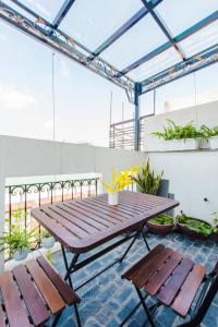 einen Picknicktisch und zwei Bänke auf einer Terrasse in der Unterkunft Nexy Living in Hanoi