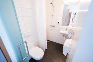 a bathroom with a toilet and a sink at Skulagardur in Garður