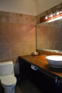a bathroom with a sink and a toilet and a mirror at Hotel Posada de Don José in Retalhuleu