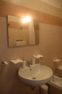 W łazience znajduje się biała umywalka i lustro. w obiekcie Landscapesilvia 1 Aria w mieście Menaggio