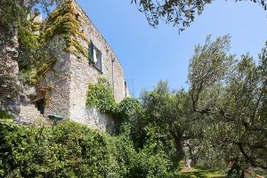 un antiguo edificio de piedra con árboles delante de él en Villa vista mare il Cipressetto, en Varigotti