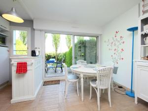 een keuken en eetkamer met een tafel en stoelen bij Apartment Le Garden by Interhome in Cabourg