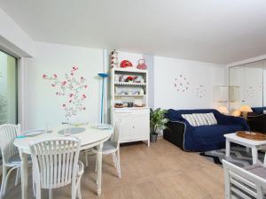 a living room with a table and a couch at Apartment Le Garden by Interhome in Cabourg