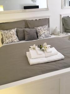 een bed met twee handdoeken en bloemen erop bij Odisey in Postojna